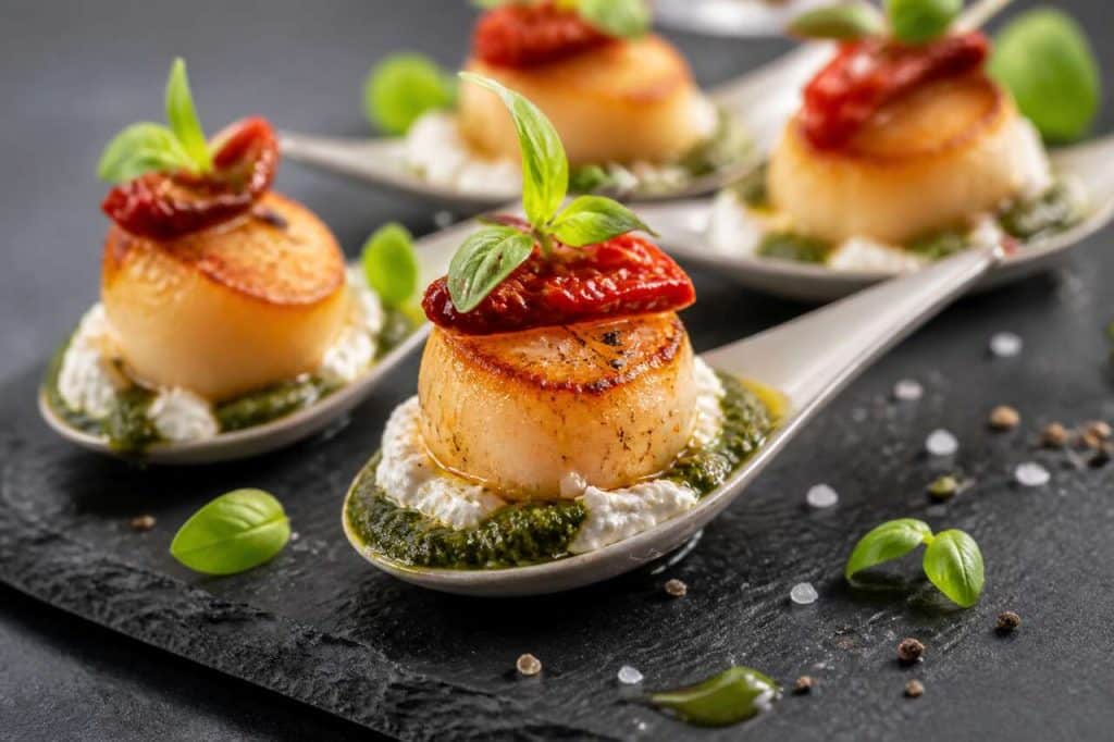 Cuillères de saint-jacques à la tomate séchée, fromage frais et pesto